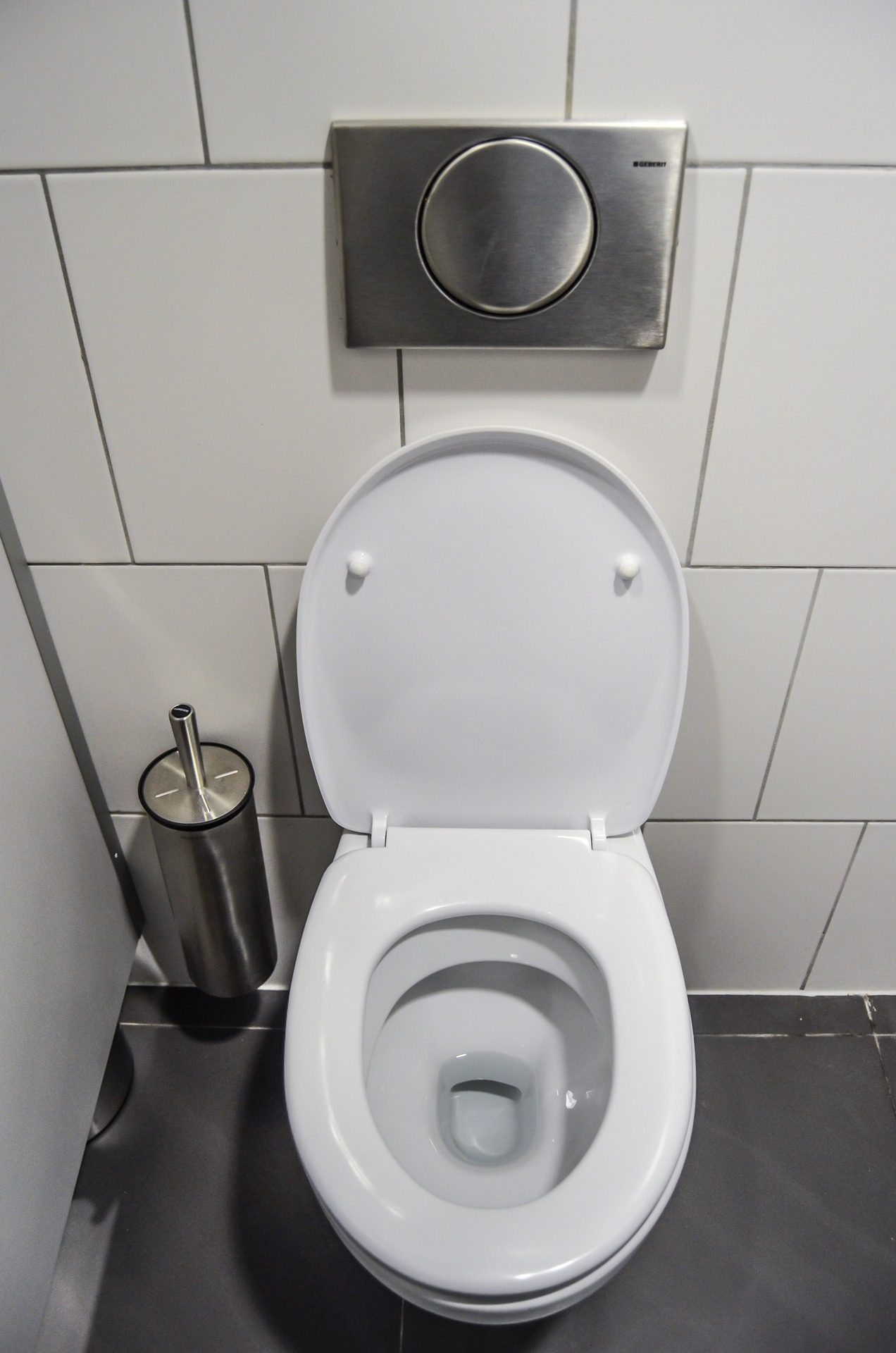 A clean white toilet in a tiled bathroom, reflecting the frequent and urgent trips that come with a urinary tract infection.